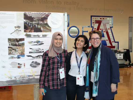 Three people pose at presentation at symposium