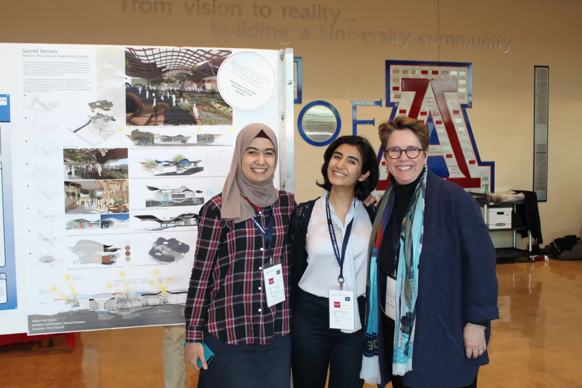 Three people pose at presentation at symposium